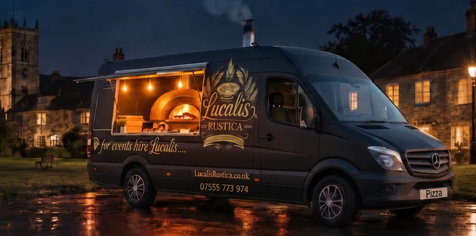 The Lucalis Rustica van lit up at night in a Kent village beside the church